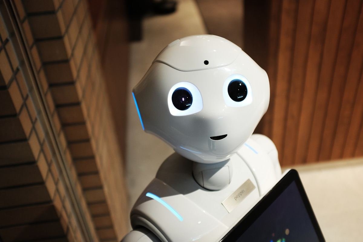 Robot blanco de asistencia junto a una pantalla