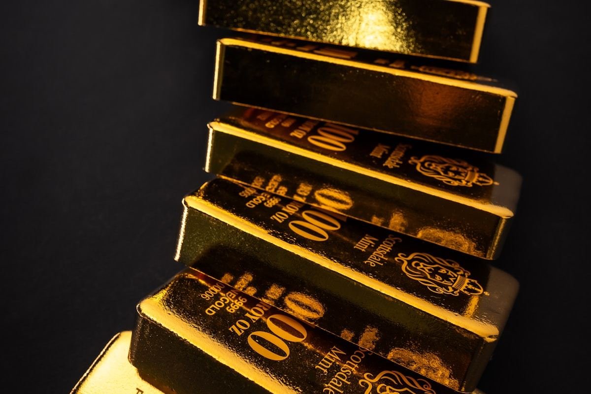 Lingotes de oro apilados sobre una superficie oscura